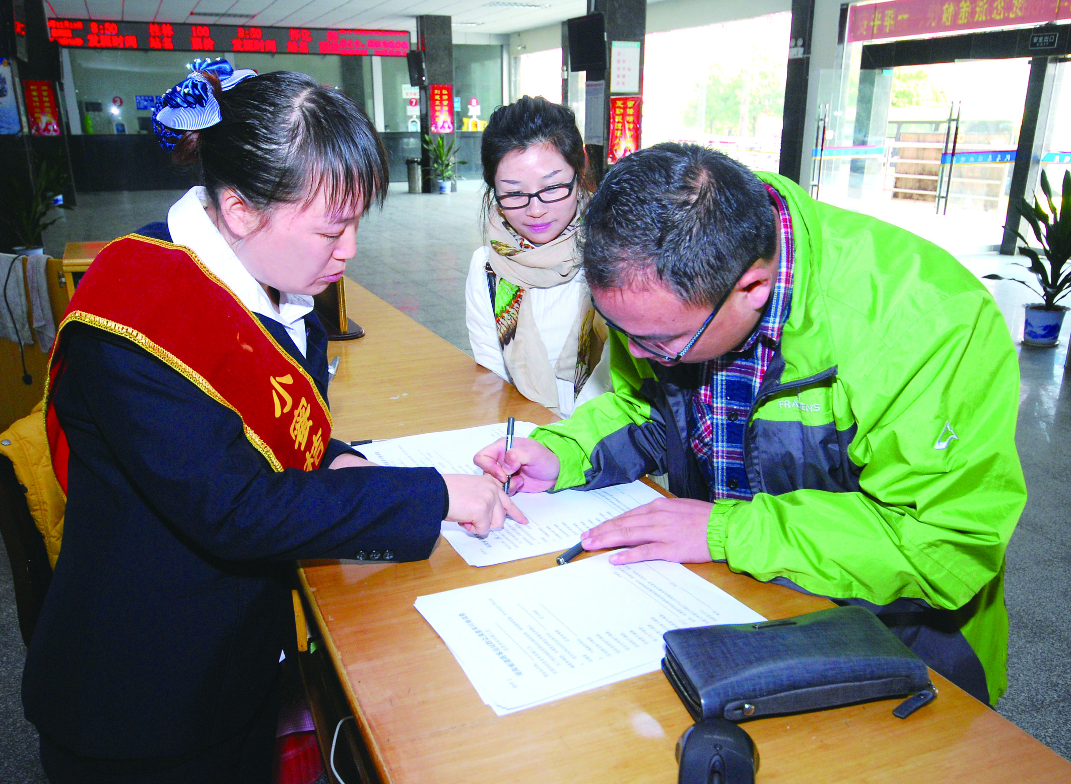 圖為洞口汽車總站站務(wù)人員在熱心為旅客服務(wù)。